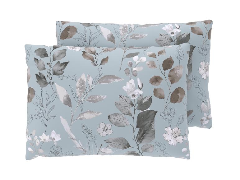 Deux oreillers à motif floral dans des tons de gris et de bleu.