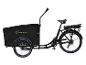 Vélo cargo électrique noir avec grande caisse avant et porte-bagages arrière.