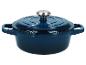 Cocotte en fonte bleu foncé avec couvercle et bouton argenté.