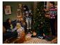 Une famille portant des pulls de Noël décore un sapin de Noël.