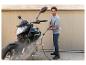 Un homme nettoie sa moto avec un nettoyeur haute pression.