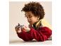 Un enfant aux cheveux bouclés, allongé sur le ventre, joue avec un vaisseau spatial Lego.