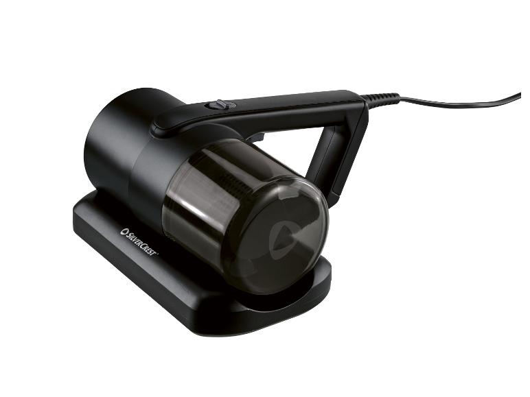 Aspirateur à main noir avec bac à poussière transparent, sur une base de chargement.