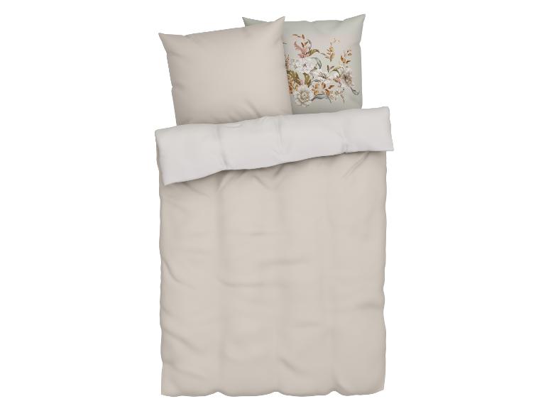 Parure de lit beige avec des oreillers fleuris.