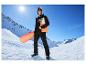 Homme en veste freeride CRIVIT et snowboard dans un paysage montagneux enneigé.