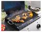 Grill en fonte Grill Ester avec poulet, saucisses et crevettes sur un barbecue.