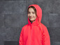 Une fille porte une veste rose à capuche.