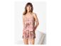 Femme souriante en pyjama caraco et short à motif abstrait rose et beige.