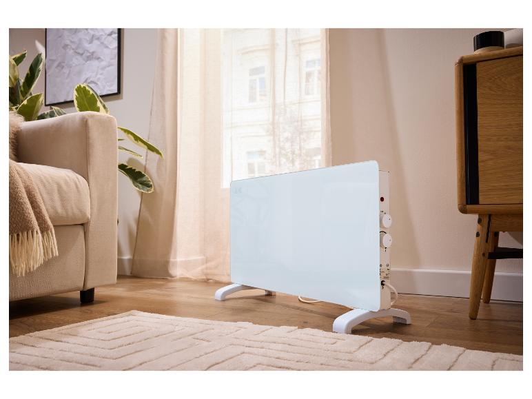 Radiateur blanc autoportant dans un salon moderne avec un canapé et des plantes.