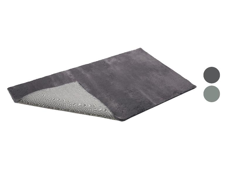 Tapis de bain rectangulaire gris foncé à texture douce et moelleuse, montrant son envers antidérapant.