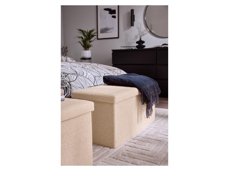 Deux poufs de rangement beiges avec une couverture bleu foncé dans une chambre à coucher.