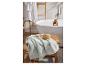 Une serviette de bain sur un tabouret en bois à côté d'une baignoire.