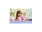 Petite fille souriante jouant avec des figurines de lapins et un panier de Pâques.