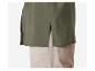 Une chemise verte à manches longues, combinée avec un pantalon beige.