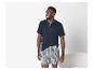 Homme en t-shirt Henley bleu foncé à manches courtes et caleçon à carreaux.