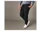 Pantalon de jogging noir avec cordon et baskets blanches.