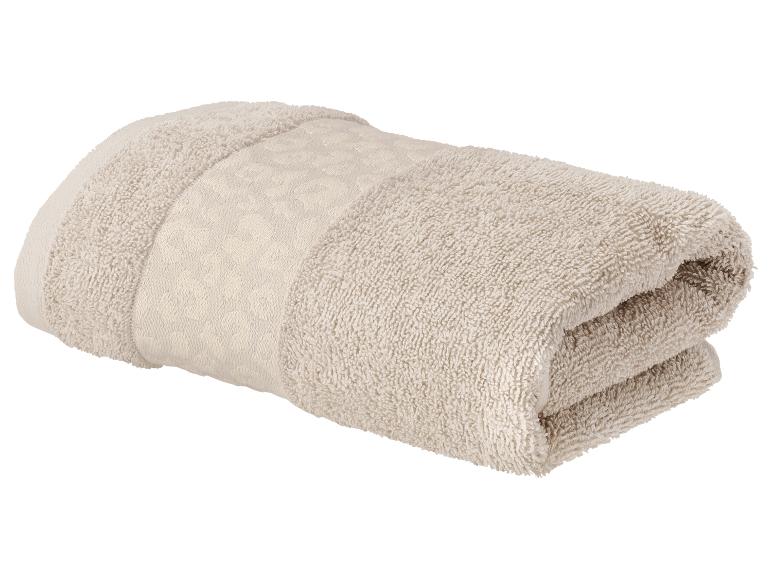 Serviette beige pliée avec une bande décorative