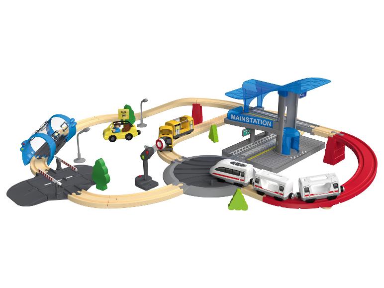 Ensemble de train et de voitures jouets avec gare principale et rails en bois.