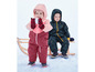 Deux enfants en vêtements d'hiver jouent dans la neige.