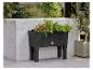 Un pot de fleurs noir sur pied de la marque Parklife avec des plantes.