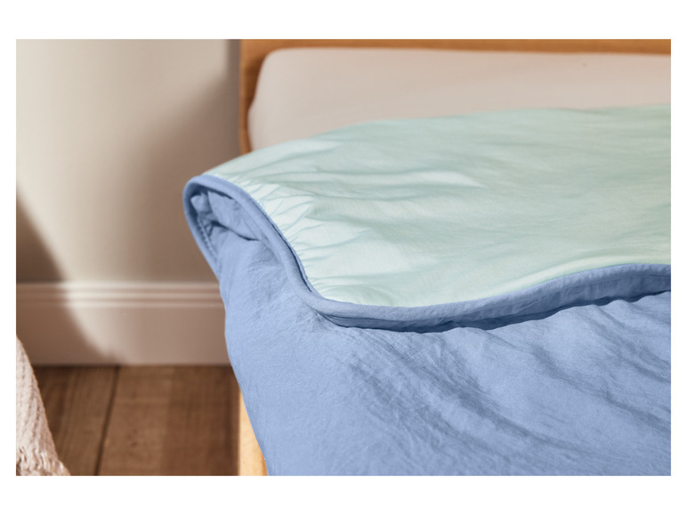 Une couette bleu clair sur un lit.