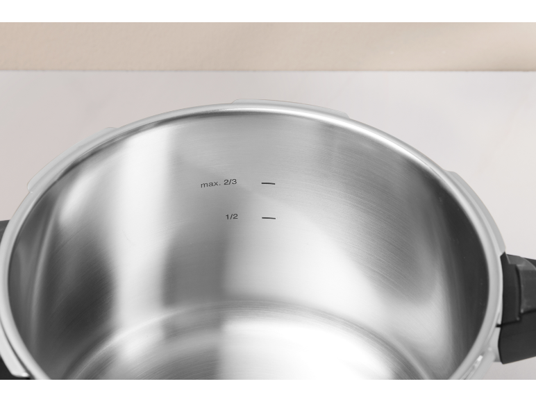 Intérieur d'une cocotte-minute en acier inoxydable avec marquages max. 2/3 et 1/2.