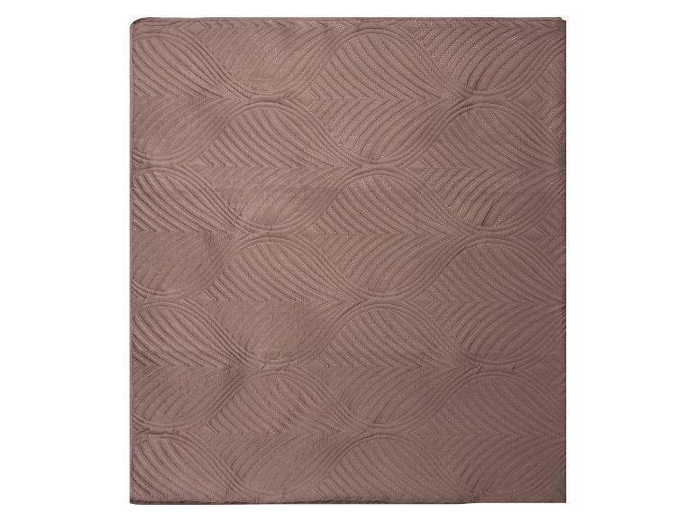 Couverture ou couvre-lit marron avec un motif matelassé ondulé et géométrique.