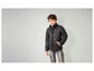 Un garçon porte une veste matelassée noire et un jean cargo gris.