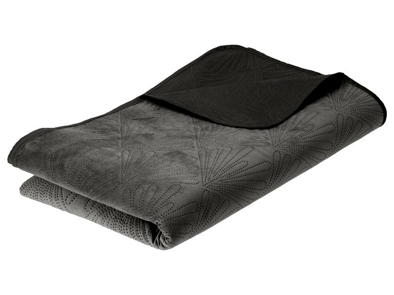 Couverture gris foncé pliée avec un motif matelassé en forme d'éventail