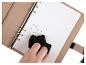 Un carnet beige, un chiffon de nettoyage et un stylo.