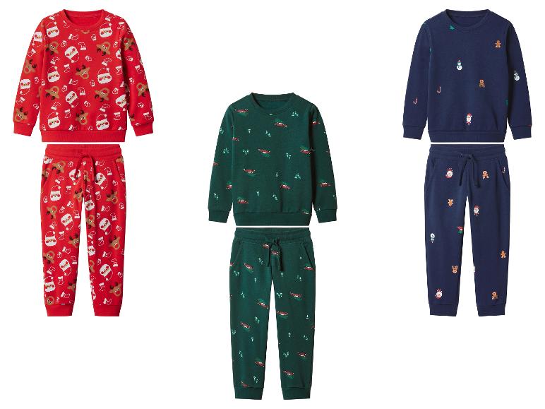 Trois ensembles de pyjamas de Noël pour enfants avec des imprimés festifs, en rouge, vert et bleu marine.