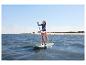 Une femme sur un stand up paddle HOME DELUXE Moana vert menthe sur l'eau.