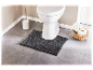 Tapis de bain gris foncé et accessoires de salle de bain.