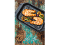 Deux pavés de saumon grillés avec du citron et des herbes dans une poêle à griller.
