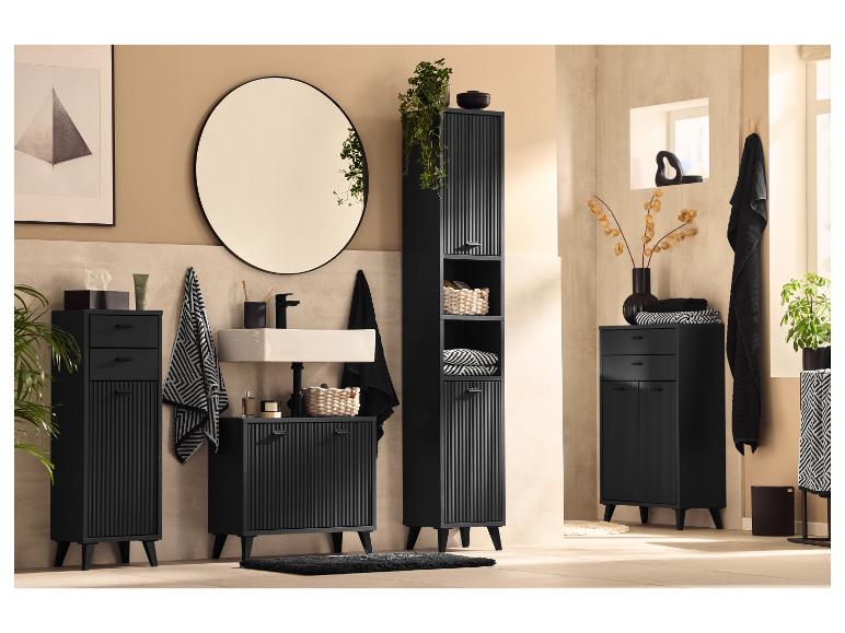 Meubles de salle de bain noirs avec finition cannelée, miroir et plantes.