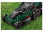 Une tondeuse à gazon Parkside verte avec des roues rouges sur l'herbe.