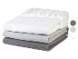 Pile de trois draps housses pliés en blanc, gris clair et gris foncé.