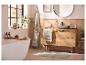 Salle de bain avec meuble vasque en bois, baignoire, miroir et plantes vertes.