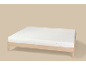 Drap-housse blanc à étoiles dorées sur un cadre de lit en bois.