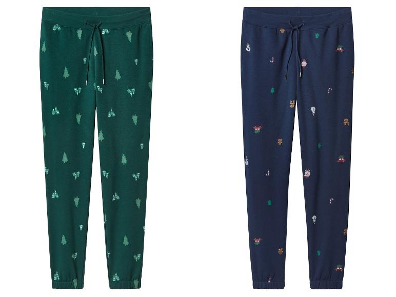 Deux pantalons de jogging, un vert avec des sapins et un bleu avec des motifs de Noël.