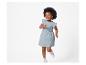 Petite fille portant une robe à pois et des baskets.