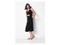 Une femme en robe noire et sandales beiges.