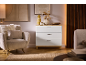 Commode blanche moderne avec trois tiroirs dans un salon chaleureux.