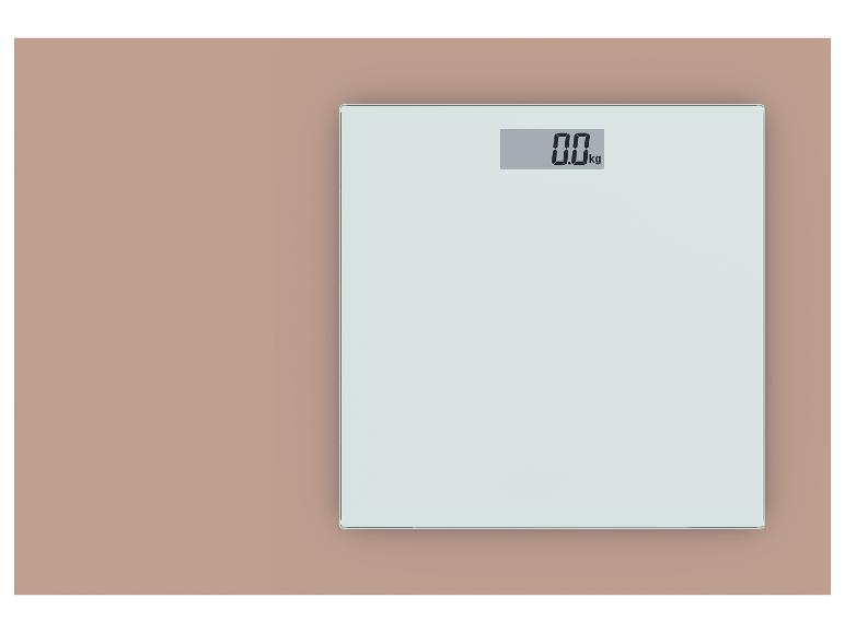 Pèse-personne numérique avec affichage de 0,0 kg sur fond rose clair.