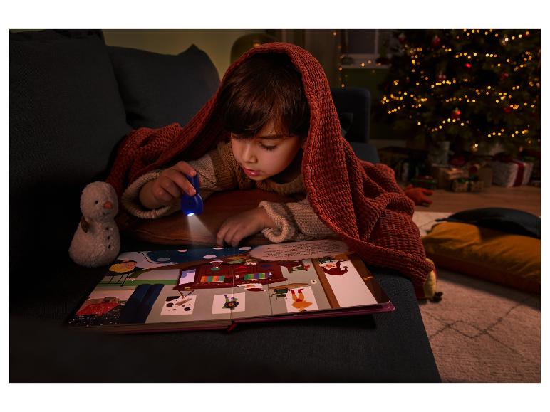 Enfant lisant un livre d'images avec une lampe de poche UV sous une couverture.