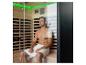 Homme assis dans un sauna infrarouge avec éclairage LED vert.