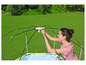 Une femme monte un parasol sur une piscine gonflable.