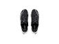 Une paire de chaussures de sport noires avec des lacets gris et des semelles blanches, vue de dessus.