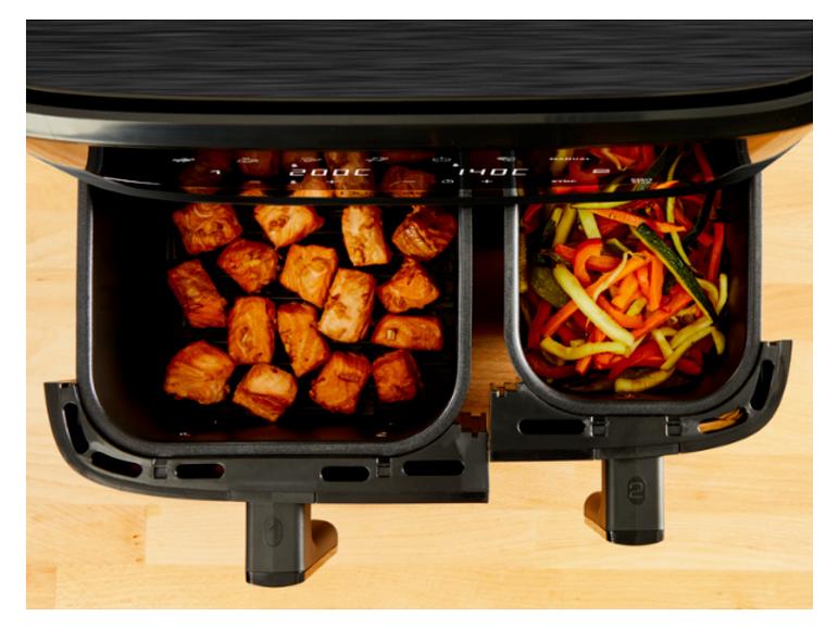 Friteuse à air double panier avec morceaux de saumon et légumes cuisant à 200°C et 140°C.
