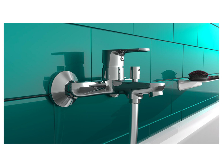 Un robinet de salle de bain chromé sur un mur de carreaux turquoise.